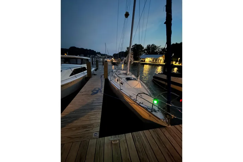 Slide: The Image of 1982 Sabre 30 sailboat docked at marina during twilight, with calm water reflections. - 3