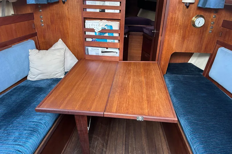 Slide: The Image of Interior of 1982 Sabre 30 sailboat with wooden table and blue cushioned seating. - 6
