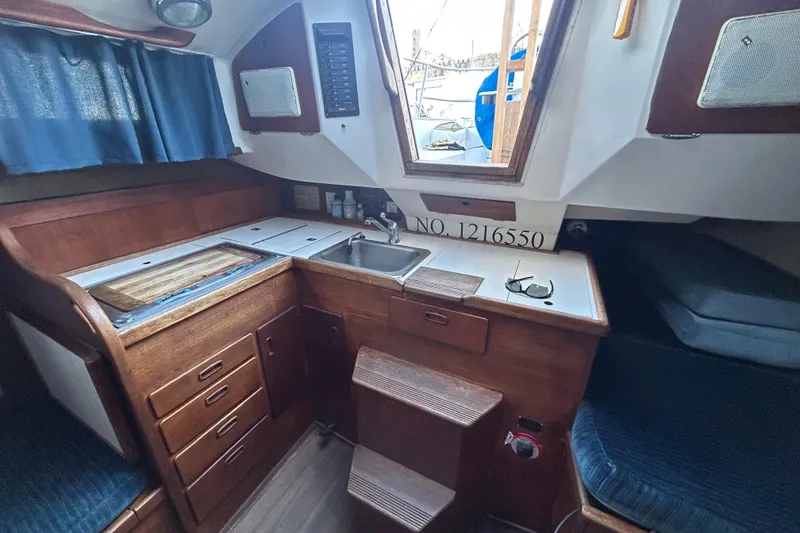 Slide: The Image of Interior of 1982 Sabre 30 sailboat galley with wood cabinetry and sink. - 7
