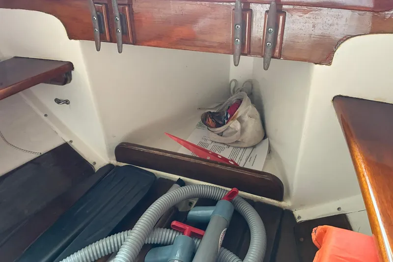 Slide: The Image of Interior of 1981 Herreshoff Doughdish 12.5 footer with storage items and wooden finish. - 10