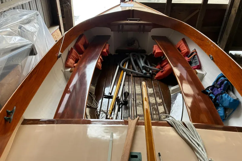 Slide: The Image of 1981 Herreshoff Doughdish 12.5 footer sailboat interior with wooden benches and nautical equipment. - 11