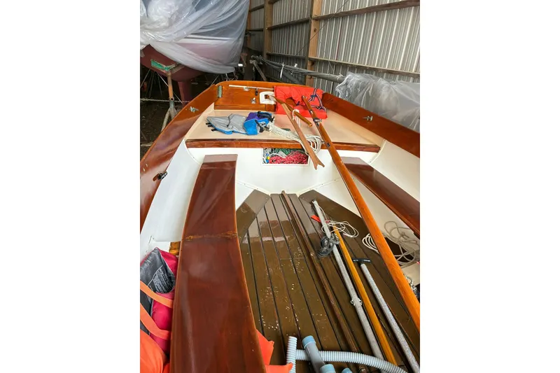 Slide: The Image of 1981 Herreshoff Doughdish 12.5 footer sailboat interior with wooden details and equipment. - 12