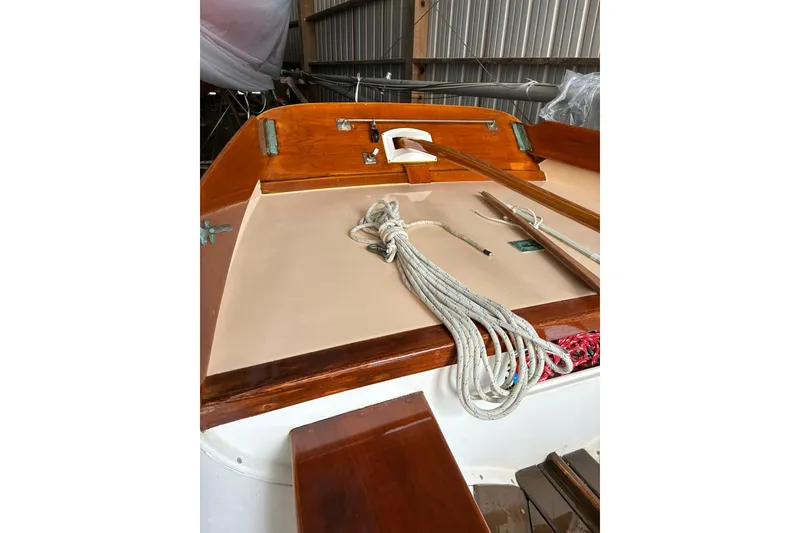 Slide: The Image of 1981 Herreshoff Doughdish 12.5 footer sailboat interior with ropes and wooden details. - 13