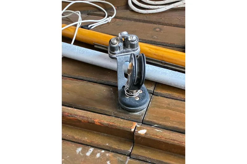 Slide: The Image of Deck hardware on 1981 Herreshoff Doughdish 12.5 footer sailboat, featuring pulley and ropes. - 17