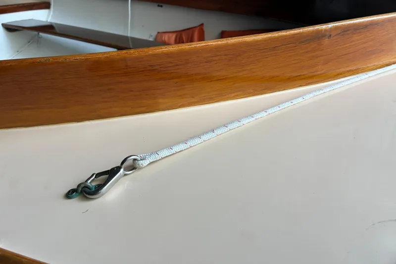 Slide: The Image of 1981 Herreshoff Doughdish 12.5 footer interior with wooden trim and rope detail. - 3