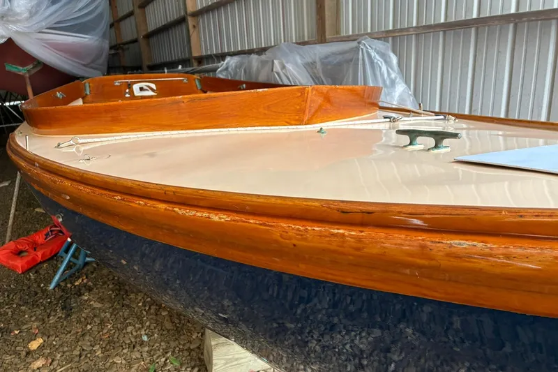 Slide: The Image of 1981 Herreshoff Doughdish 12.5 footer sailboat with wooden trim in storage. - 5