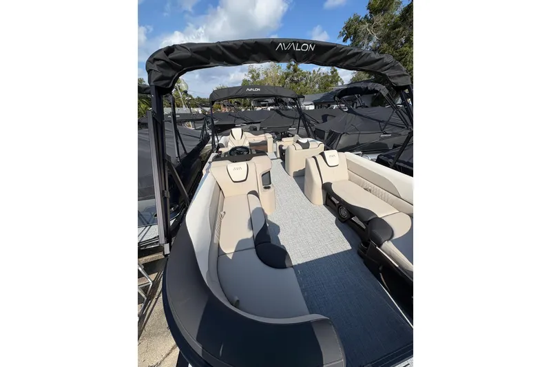 Slide: The Image of 2026 Avalon LSZ ELITE pontoon boat with luxurious seating and canopy under blue sky. - 3