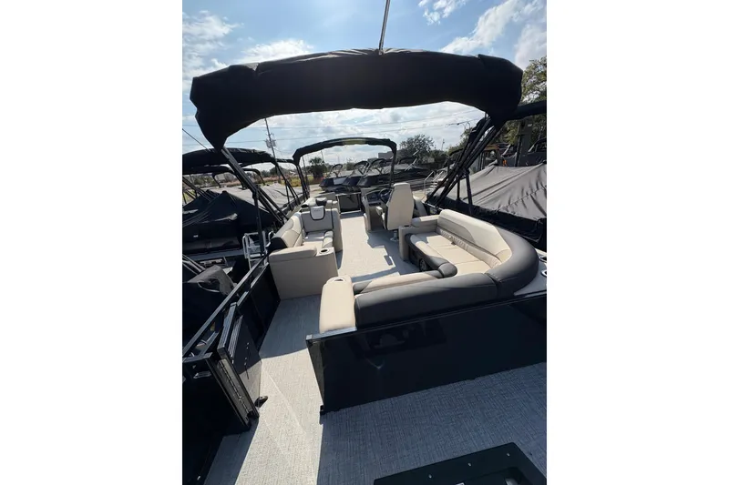 Slide: The Image of 2026 Avalon LSZ ELITE pontoon boat interior with plush seating and canopy under a sunny sky. - 6