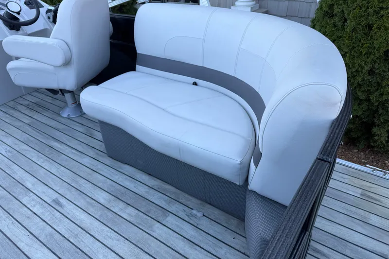 Slide: The Image of 2017 Crest I 220 SLC boat interior with white seating and wooden deck. - 14