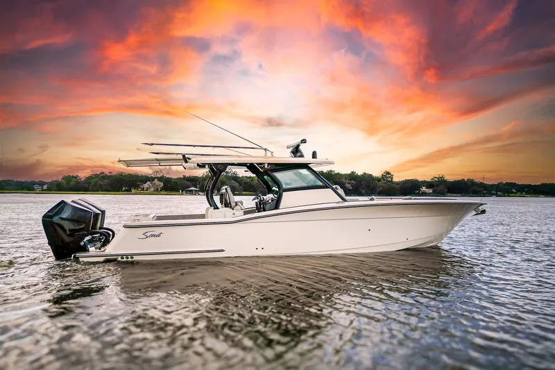 Slide: The Image of 2024 Scout 377 LXF boat on calm water under a partly cloudy sky. - 1