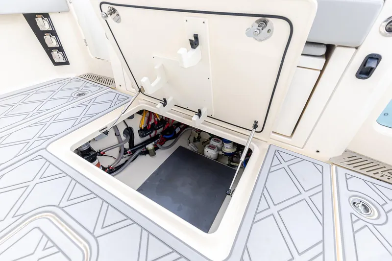 Slide: The Image of 2024 Scout 377 LXF boat hatch open, revealing internal wiring and components. - 12