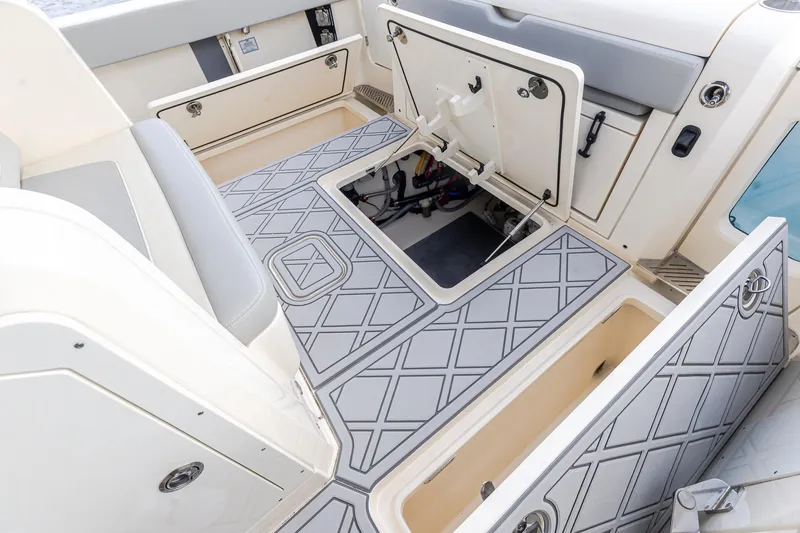 Slide: The Image of 2024 Scout 377 LXF boat interior with open storage compartments and patterned flooring. - 14