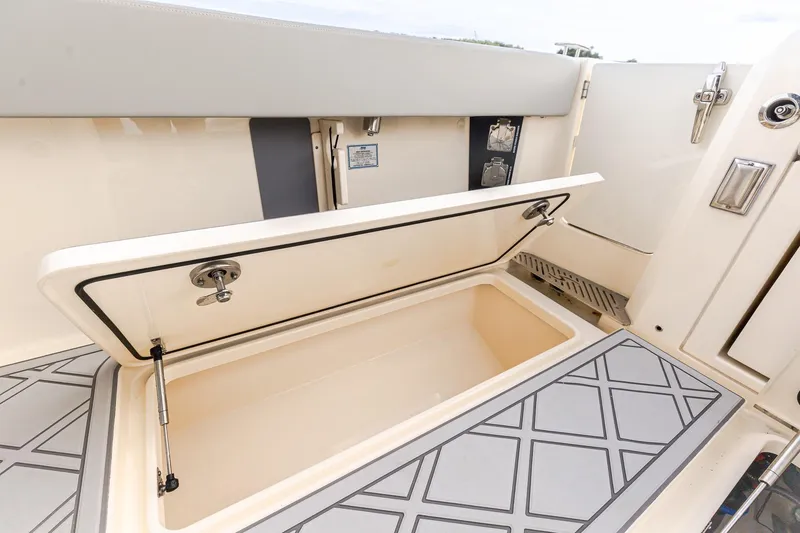Slide: The Image of 2024 Scout 377 LXF boat storage compartment with open lid, showcasing interior design. - 16
