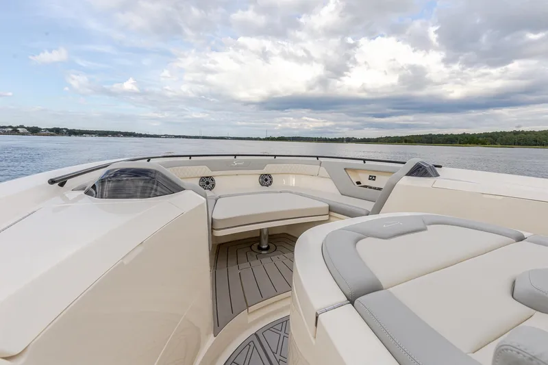 Slide: The Image of 2024 Scout 377 LXF boat interior with luxurious seating on a calm water backdrop. - 53