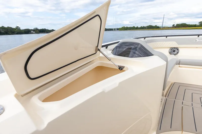 Slide: The Image of 2024 Scout 377 LXF boat with open storage compartment, luxurious seating, and scenic water view. - 57