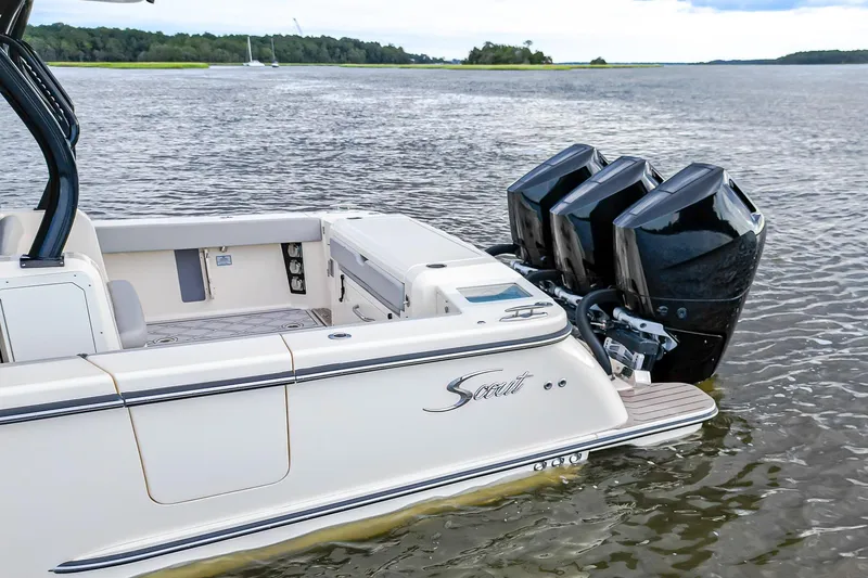Slide: The Image of 2024 Scout 377 LXF boat with triple outboard engines on a calm lake. - 6