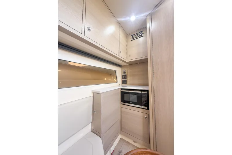 Slide: The Image of 2024 Scout 377 LXF interior with modern cabinetry and built-in microwave. - 80