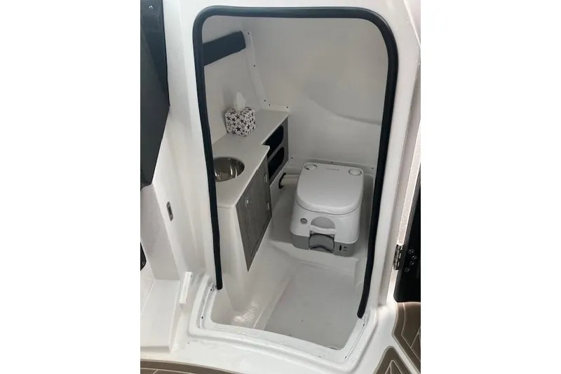 Slide: The Image of 2024 Monterey 258SS Super Sport boat interior with compact toilet and sink. - 10