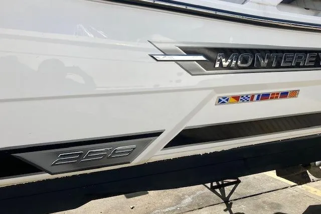 Slide: The Image of 2024 Monterey 258SS Super Sport boat with nautical flags and sleek design. - 3