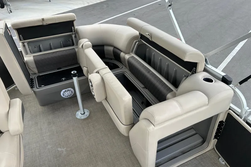 Slide: The Image of 2023 Sun Tracker Party Barge 20 DLX interior with beige seating and storage compartments. - 15