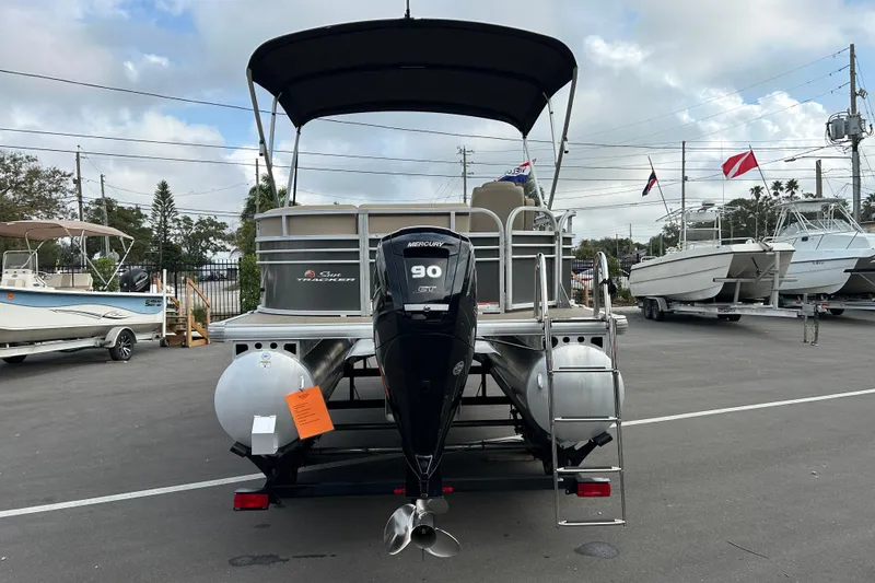 Slide: The Image of 2023 Sun Tracker Party Barge 20 DLX pontoon boat with Mercury 90 engine, parked outdoors. - 3