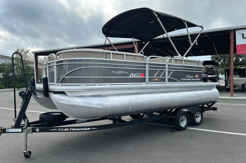Slide: The Image of 2023 Sun Tracker Party Barge 20 DLX pontoon boat on trailer, parked outdoors. - 5