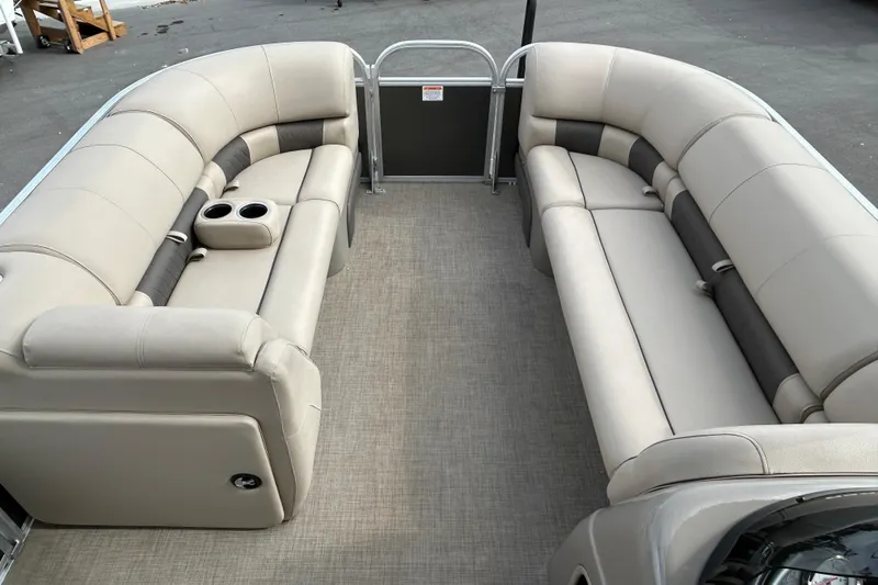 Slide: The Image of 2023 Sun Tracker Party Barge 20 DLX interior with beige seating and cup holders. - 8