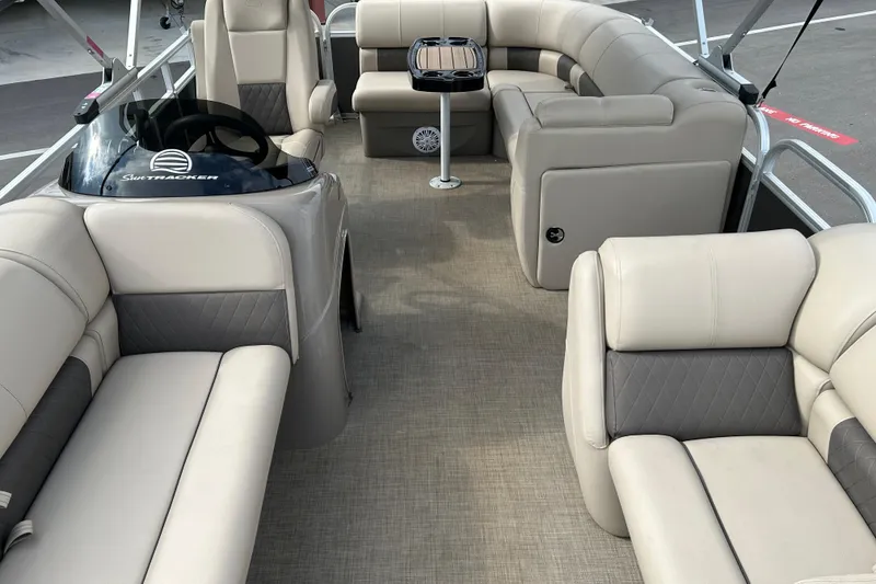 Slide: The Image of 2023 Sun Tracker Party Barge 20 DLX interior with plush seating and steering console. - 9