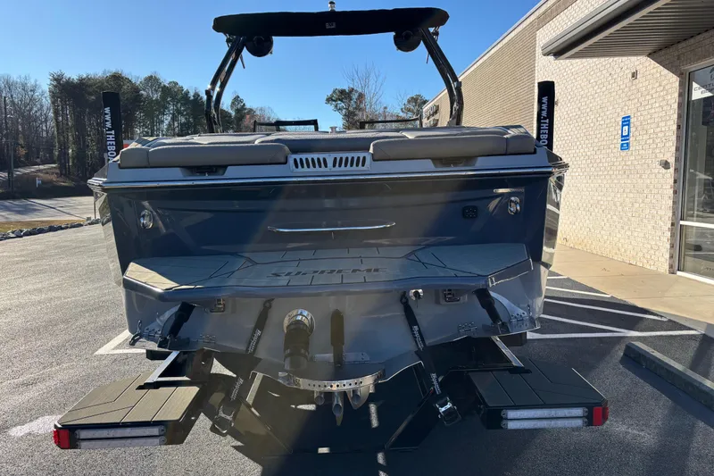 Slide: The Image of 2026 Supreme S240 boat rear view, parked outdoors, showcasing sleek design and modern features. - 4