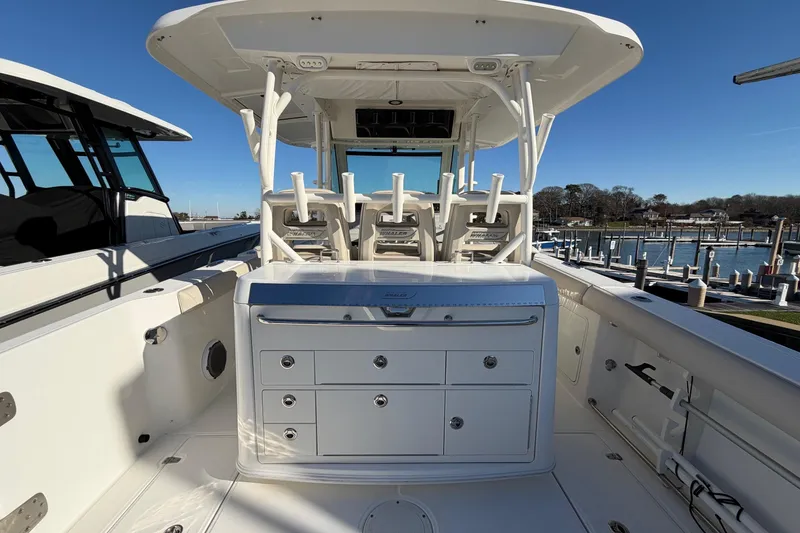 Slide: The Image of 2017 Boston Whaler 350 Outrage boat interior with seating and storage, docked by the marina. - 13