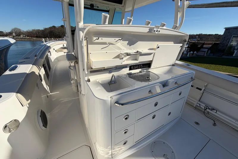 Slide: The Image of 2017 Boston Whaler 350 Outrage boat interior with sleek white cabinetry and sink. - 14