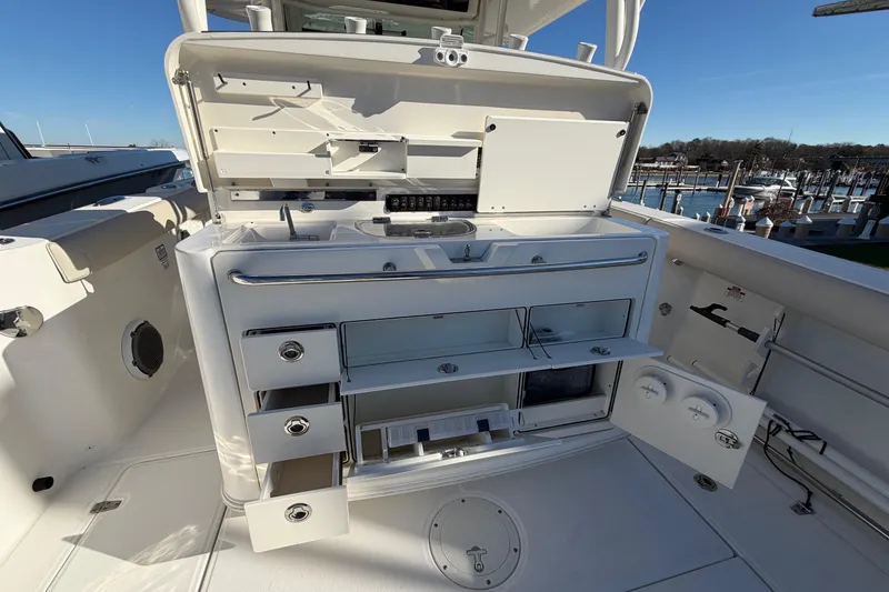 Slide: The Image of 2017 Boston Whaler 350 Outrage boat interior with open storage compartments and drawers. - 15