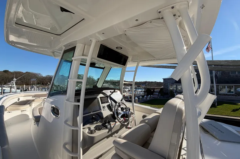 Slide: The Image of 2017 Boston Whaler 350 Outrage cockpit with helm, seating, and marina view. - 20