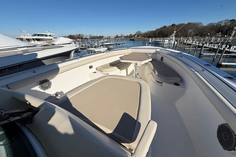 Slide: The Image of 2017 Boston Whaler 350 Outrage boat interior with seating and table, docked by the water. - 29