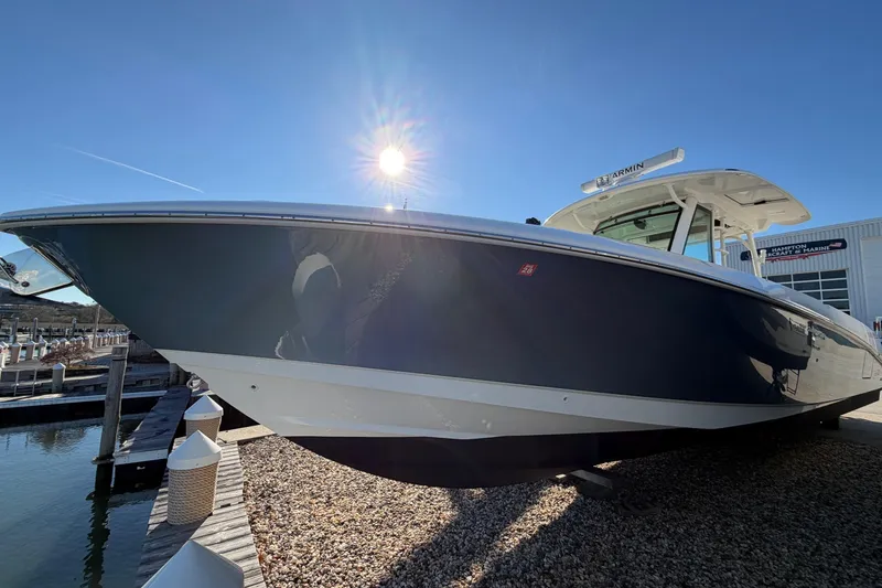 Slide: The Image of 2017 Boston Whaler 350 Outrage boat with Mercury engine, docked on gravel. - 37