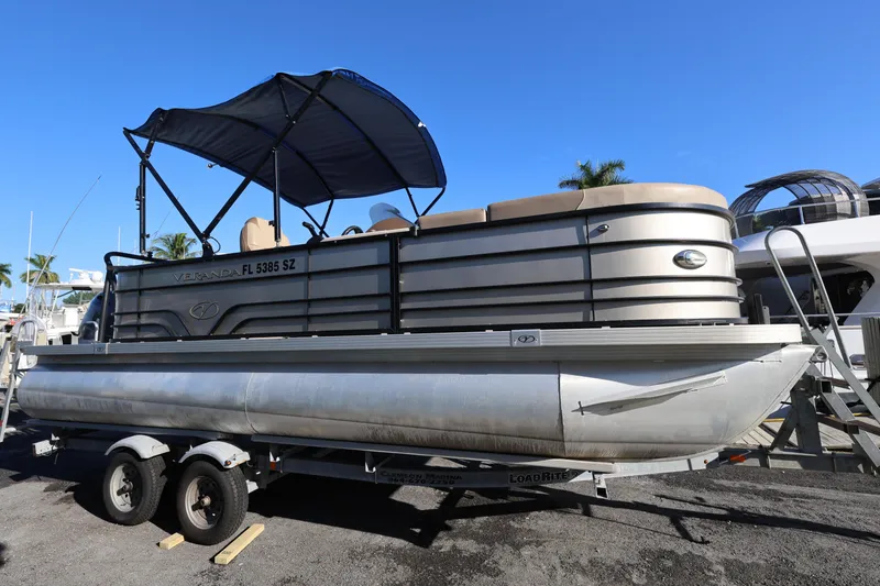 The Image of 2019 Veranda 22 VR pontoon boat on trailer with canopy, parked outdoors. - 1
