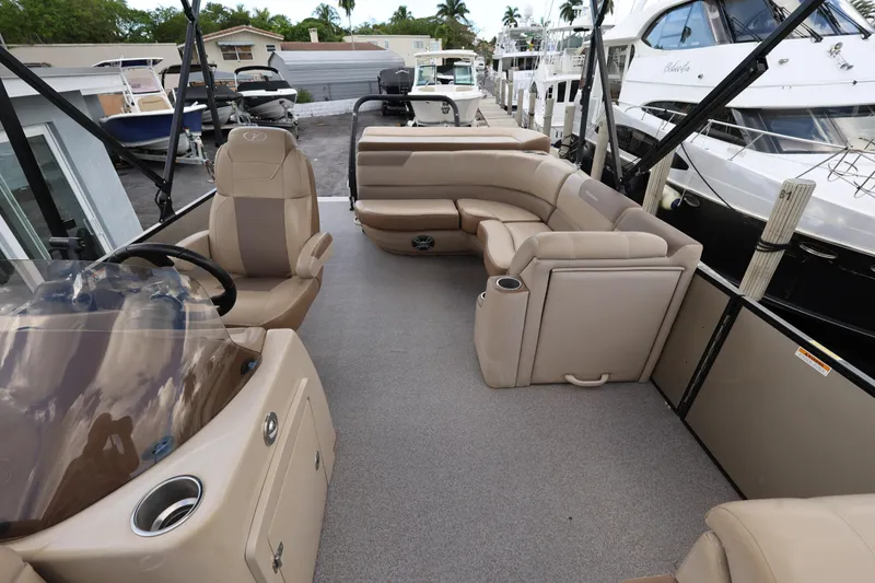 Slide: The Image of 2019 Veranda 22 VR pontoon boat interior with beige seating and steering console. - 15