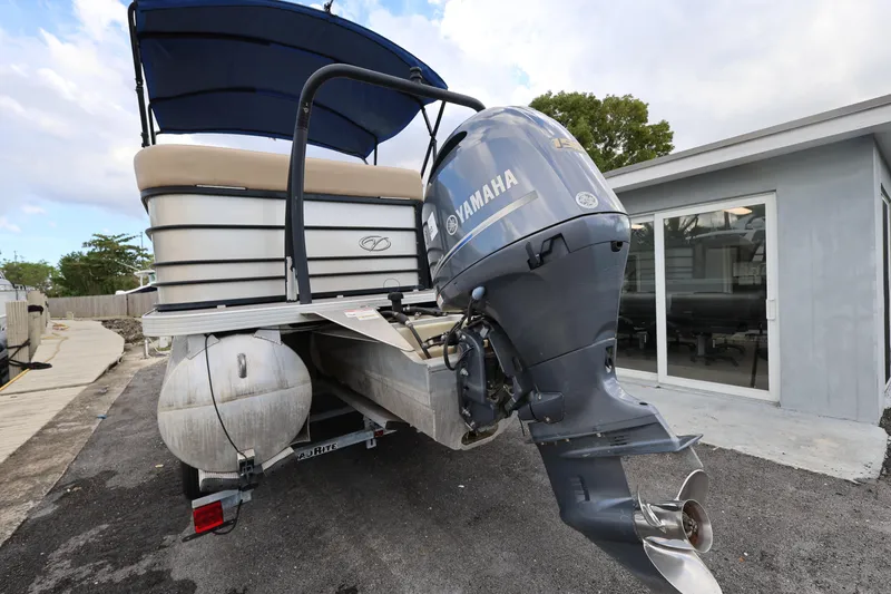 Slide: The Image of 2019 Veranda 22 VR pontoon boat with Yamaha outboard motor, parked near a building. - 6