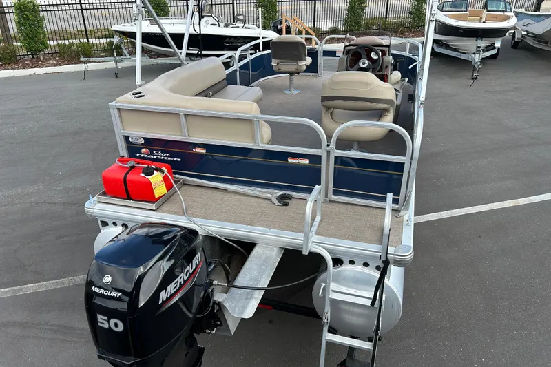 Slide: The Image of 2021 Sun Tracker Bass Buggy 16 XL pontoon boat with Mercury 50 engine, parked outdoors. - 7