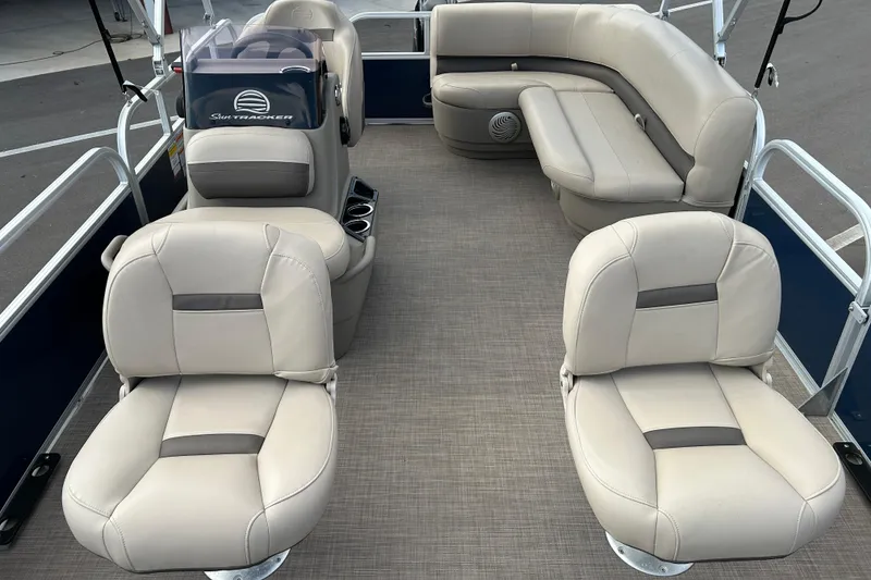 Slide: The Image of 2021 Sun Tracker Bass Buggy 16 XL pontoon boat interior with beige seating and helm. - 9