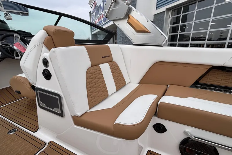 Slide: The Image of 2022 MasterCraft X26 boat interior with tan and white seating, modern design. - 12