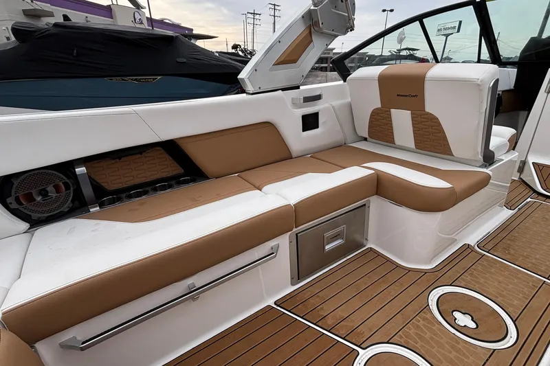 Slide: The Image of 2022 MasterCraft X26 boat interior with tan and white seating, modern design. - 16