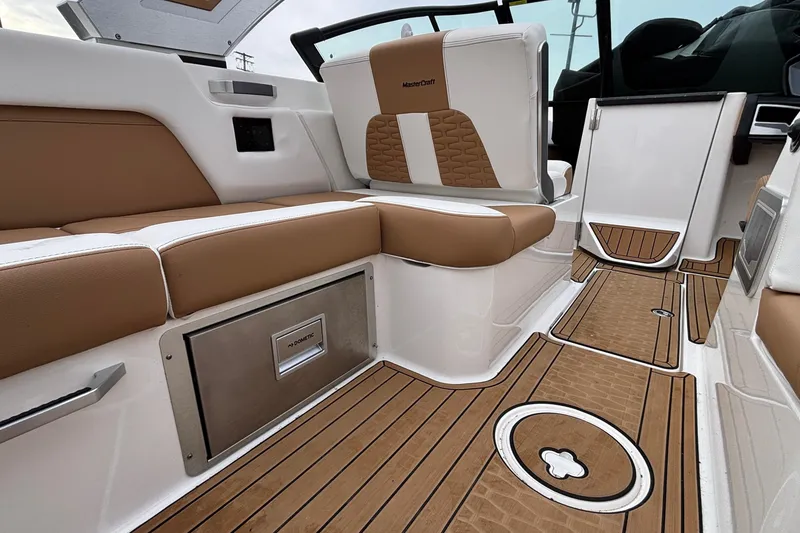 Slide: The Image of 2022 MasterCraft X26 interior with tan and white seating, teak-style flooring. - 17