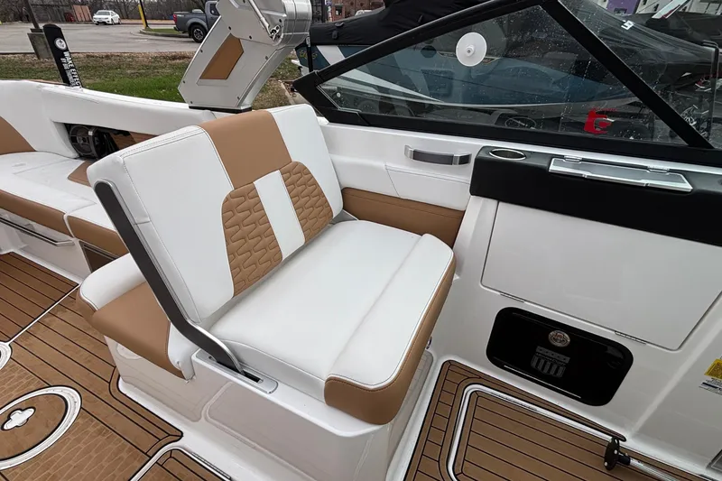 Slide: The Image of 2022 MasterCraft X26 boat interior with tan and white seating, modern design. - 18