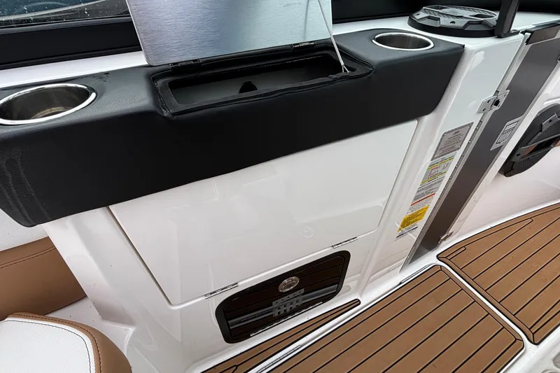 Slide: The Image of 2022 MasterCraft X26 interior with cup holders and teak-style flooring. - 24