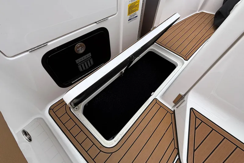 Slide: The Image of 2022 MasterCraft X26 boat storage compartment with teak flooring detail. - 26