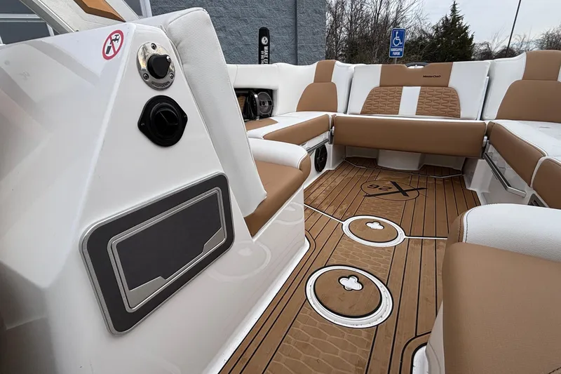Slide: The Image of 2022 MasterCraft X26 boat interior with tan and white seating, wood-style flooring. - 27