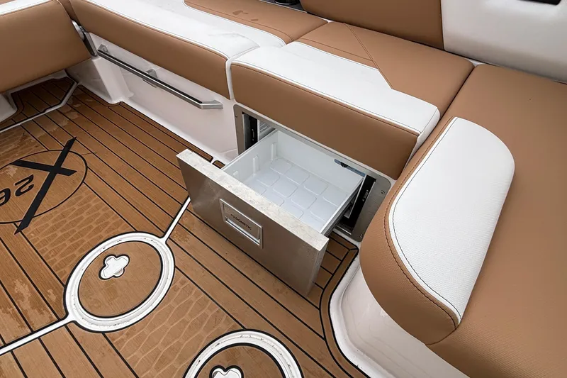 Slide: The Image of 2022 MasterCraft X26 boat interior with open storage drawer and teak flooring. - 28