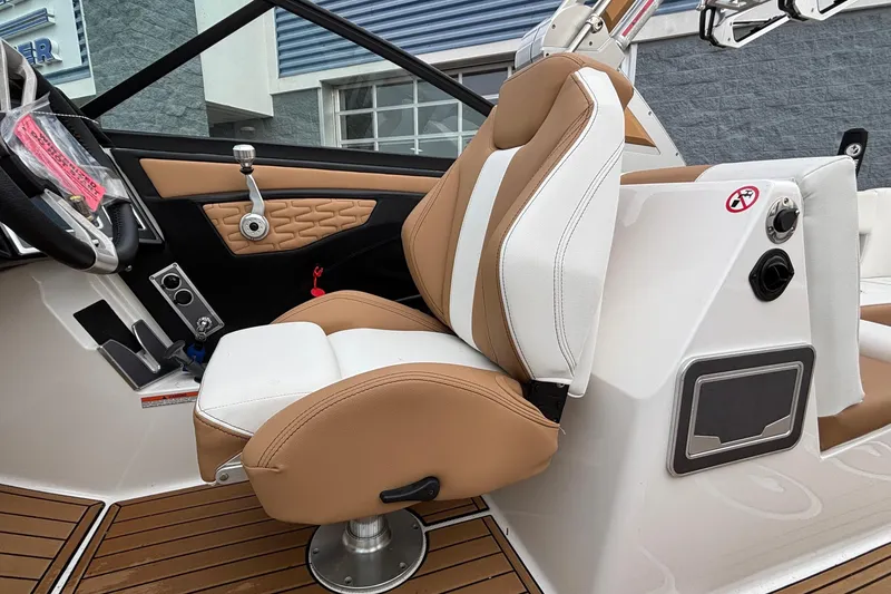 Slide: The Image of 2022 MasterCraft X26 boat interior with tan and white captain's seat. - 38