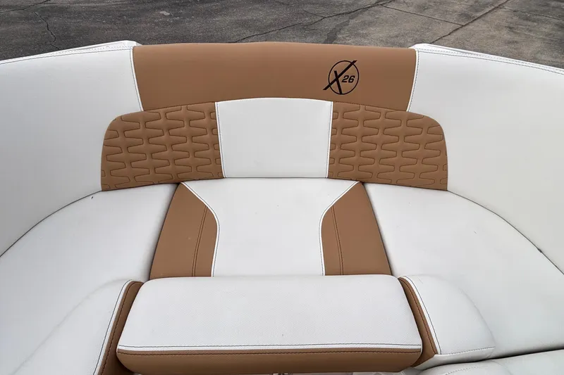 Slide: The Image of 2022 MasterCraft X26 boat interior with tan and white cushioned seating. - 53